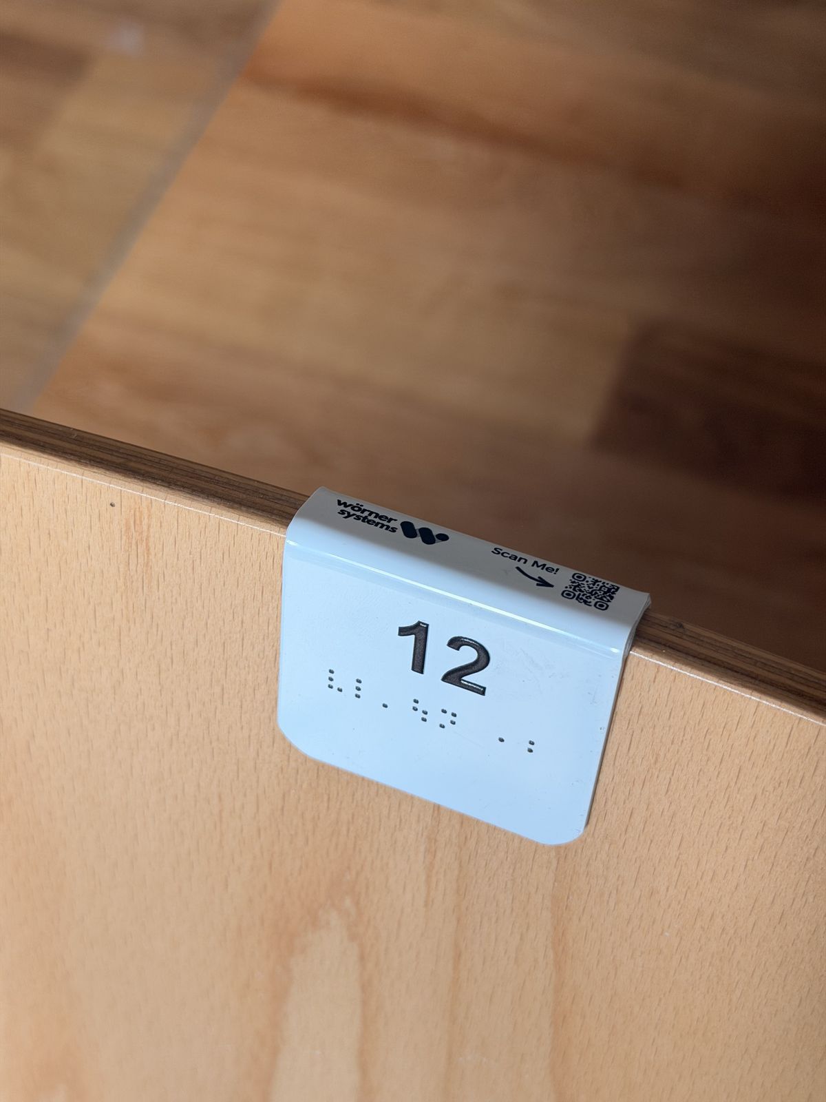 Platznummer 12 mit Blindenschrift Braille auf Holzlehne