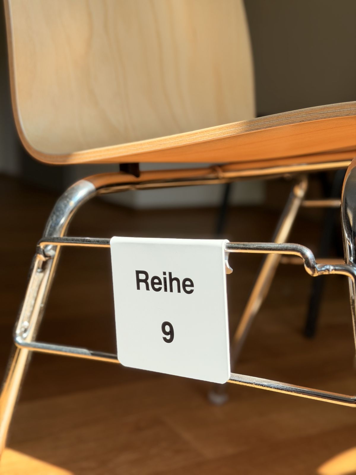 Weißer Reihen-Clip Reihe 9 am Chromrohr eines Stuhls